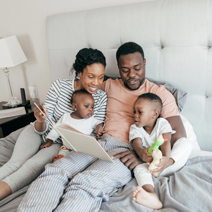 family of four reading in bed