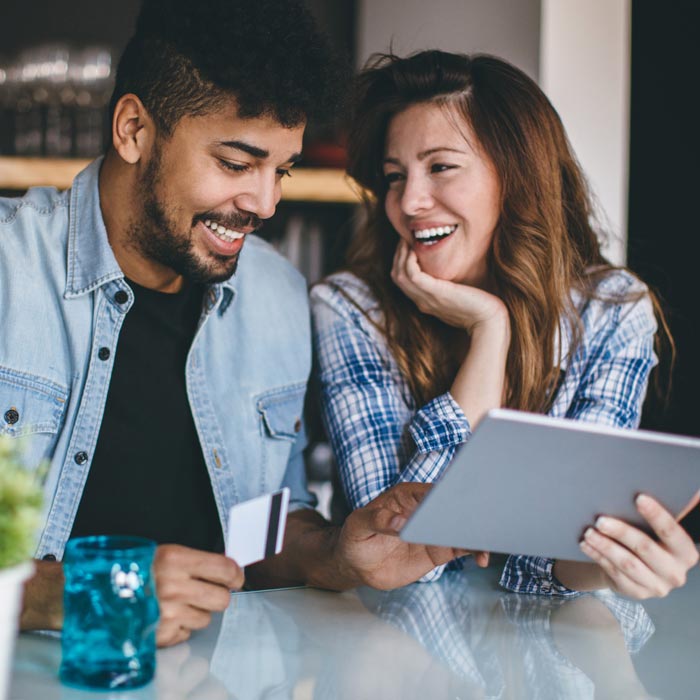 couple laughing at tablet